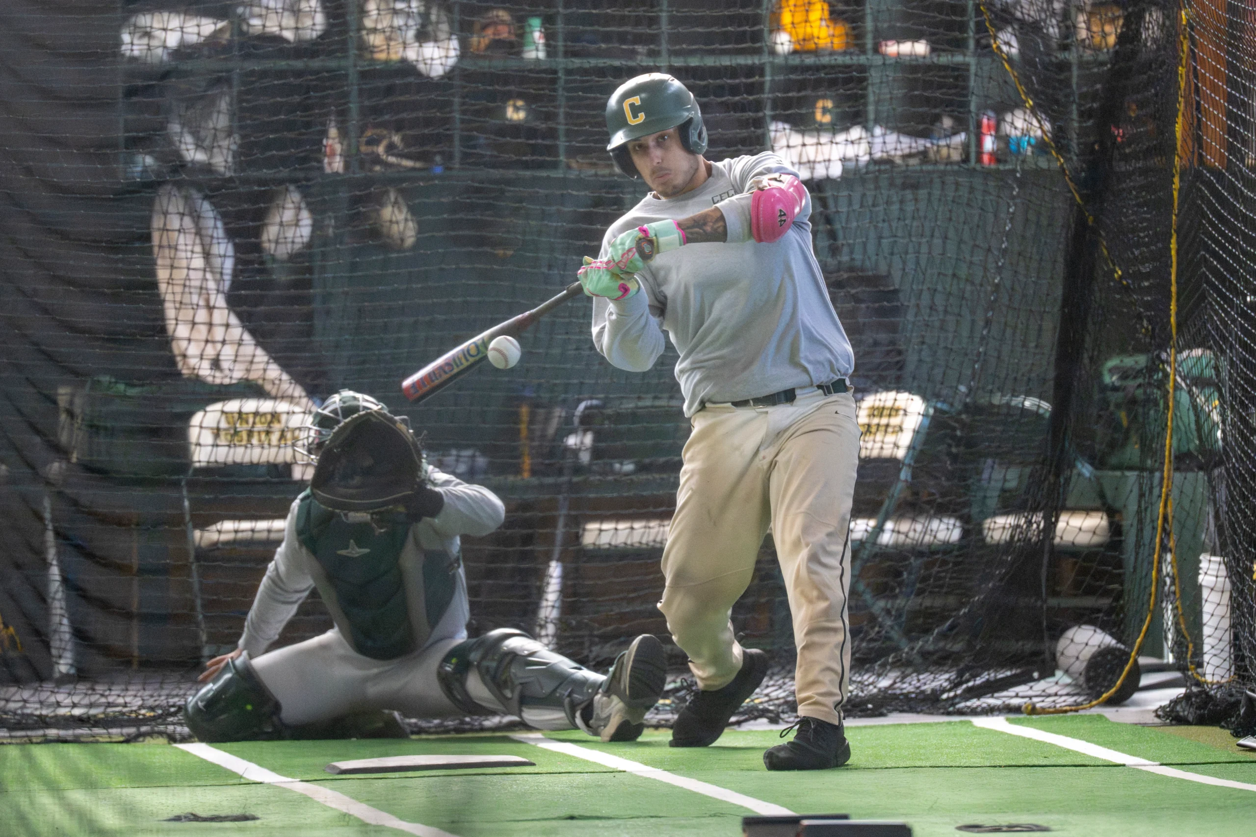 baseball player hitting in cage